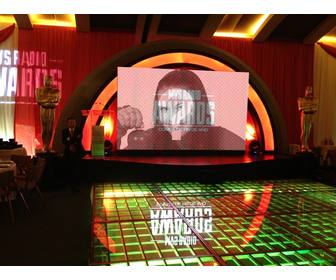 photomontage of mvs radio awards with oscars statues next to the stage and big screen to place picture uploaded online
