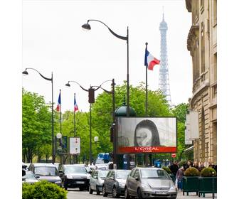 photomontage of billboard in paris with the eiffel tower in the background and several flags of france